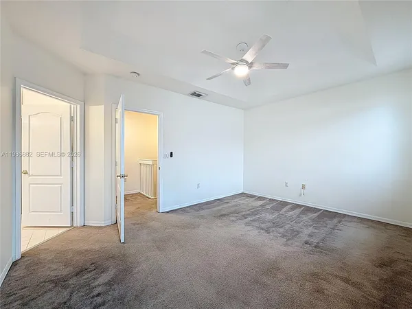 an empty room with closet and a chandelier fan