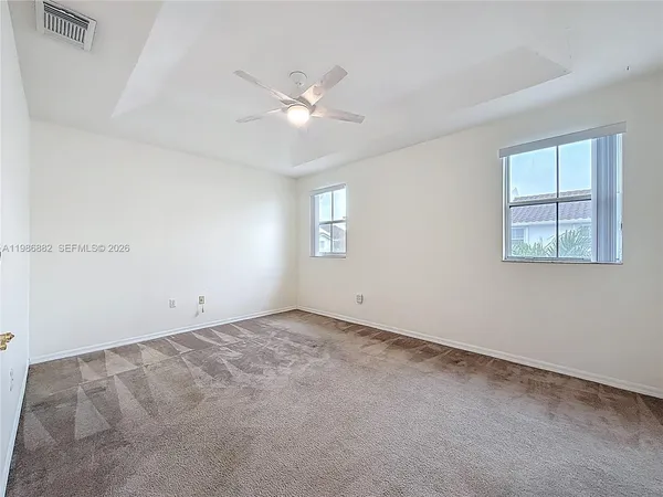 an empty room with windows and fan