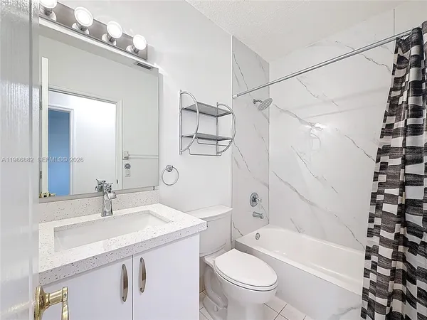a bathroom with a sink a toilet a mirror a vanity and shower