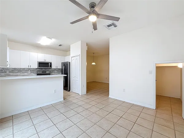 a kitchen with granite countertop a refrigerator and a stove top oven