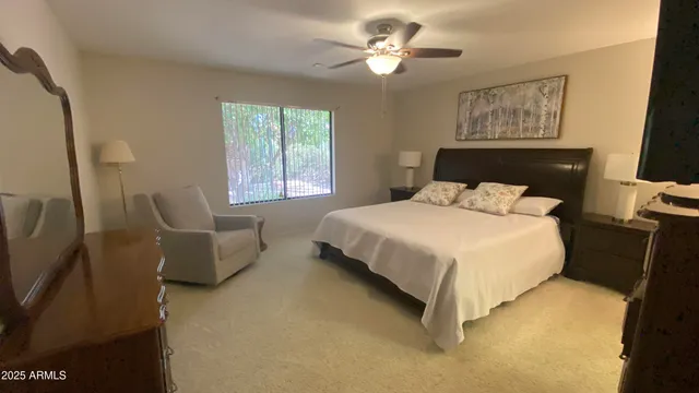 a bedroom with a bed and a flat tv screen on dresser