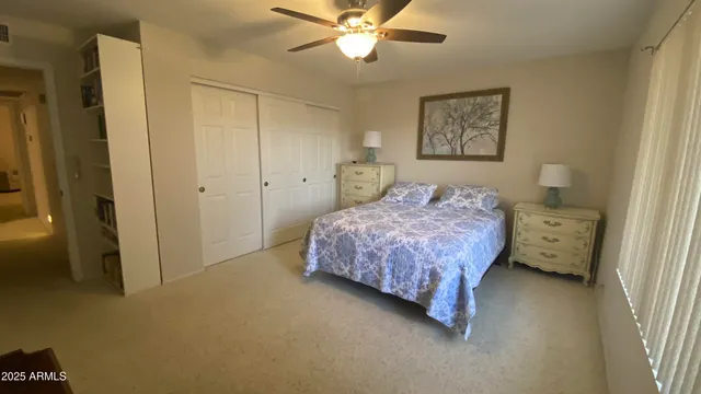a bedroom with a bed and a ceiling fan