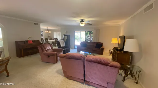 a dining room with furniture a chandelier and wooden floor