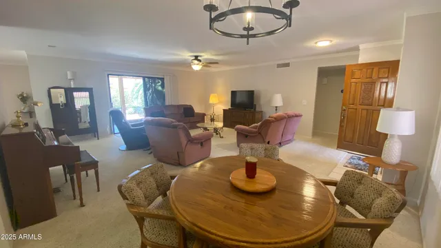 a living room with furniture a chandelier and a flat screen tv