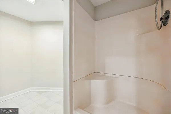 a view of an empty room with a chandelier fan