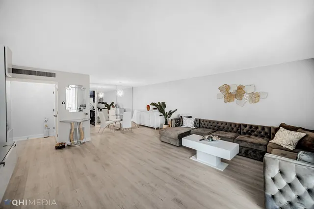a living room with furniture a flat screen tv and a wooden floor