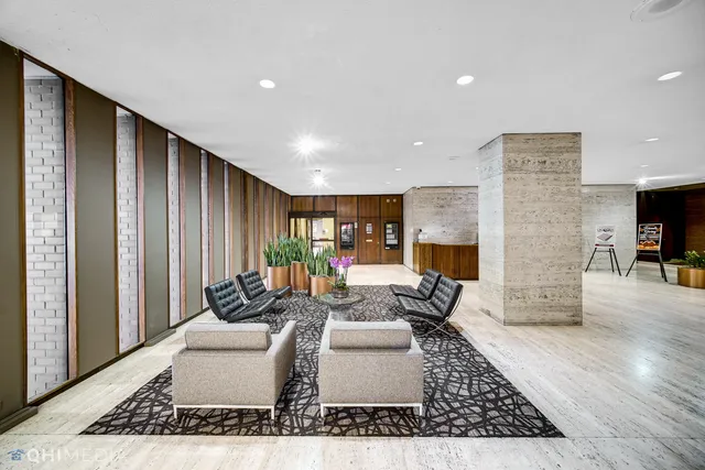 a living room with fireplace furniture and a rug