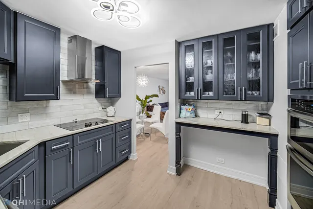 a large kitchen with stainless steel appliances a sink and cabinets