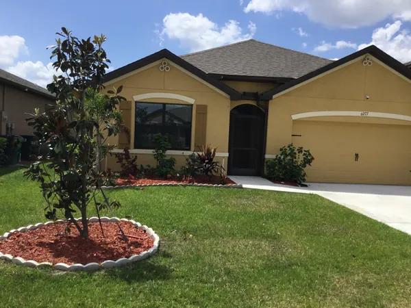 a front view of a house with a garden