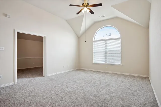 an empty room with a ceiling fan and window
