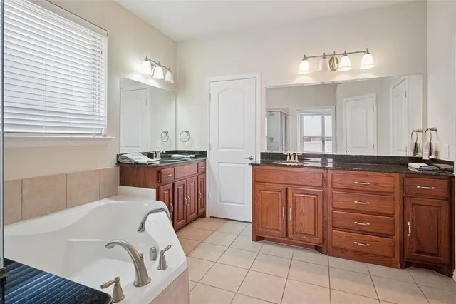 a bathroom with a tub sink and mirror
