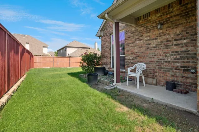 a view of a chair and table in backyard of the house