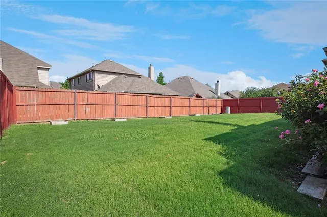 a view of a green field with house in the background