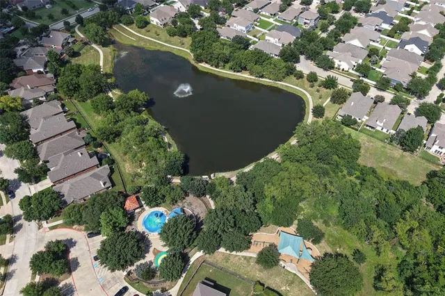 an aerial view of a house with a yard and lake view