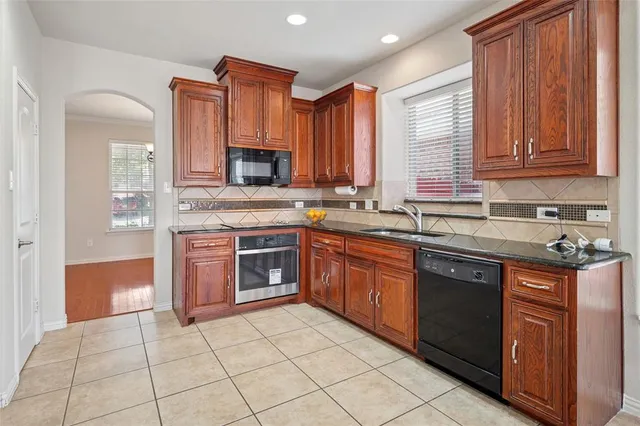 a kitchen with stainless steel appliances granite countertop a stove sink and cabinets