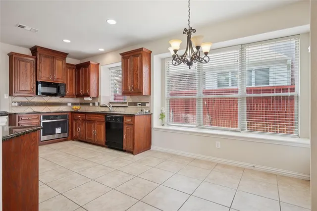 a kitchen with stainless steel appliances granite countertop a stove a sink dishwasher a refrigerator and a microwave