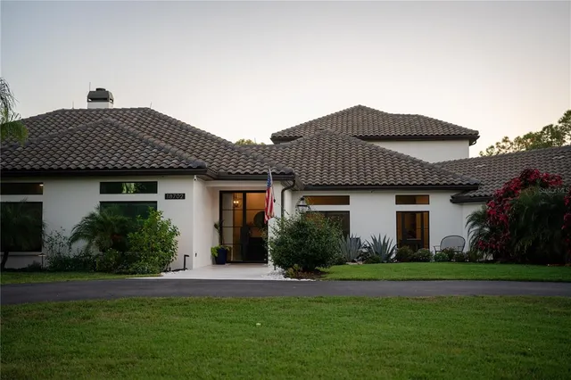 a view of a house with a small yard and floor to ceiling window
