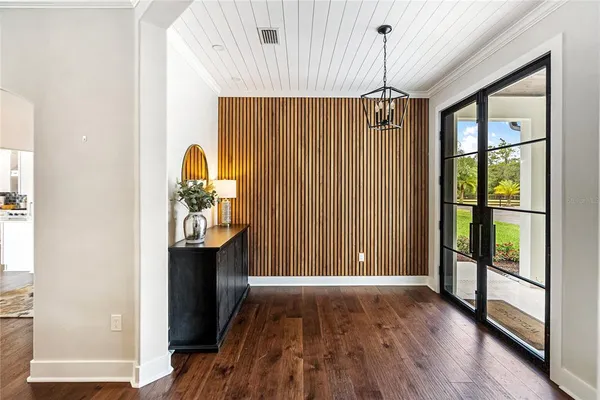 a view of hallway with wooden floor and windows