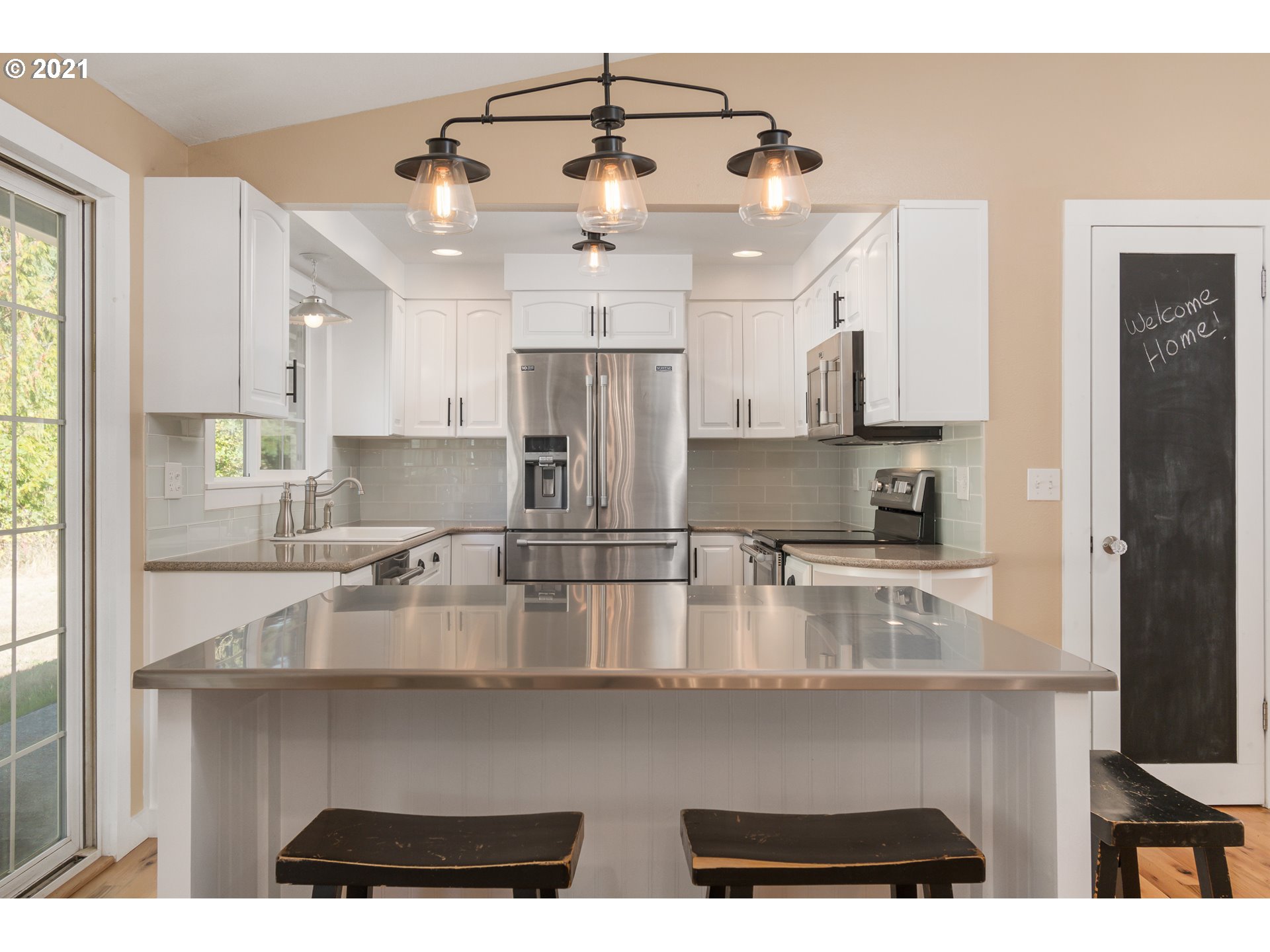 69021 Nicolai Road Rainier, OR 97048 - Photo 7 of 32 a kitchen with stainless steel appliances granite countertop a refrigerator a sink dishwasher a stove and white cabinets with wooden floor