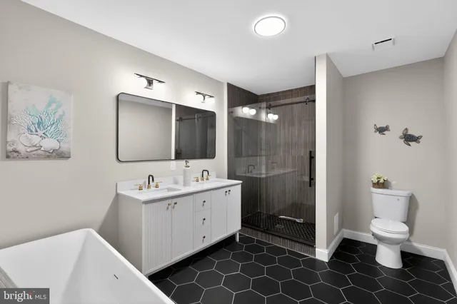 a bathroom with a double vanity sink toilet mirror and shower