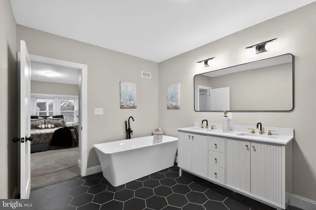 a bathroom with a double vanity sink mirror and bathtub
