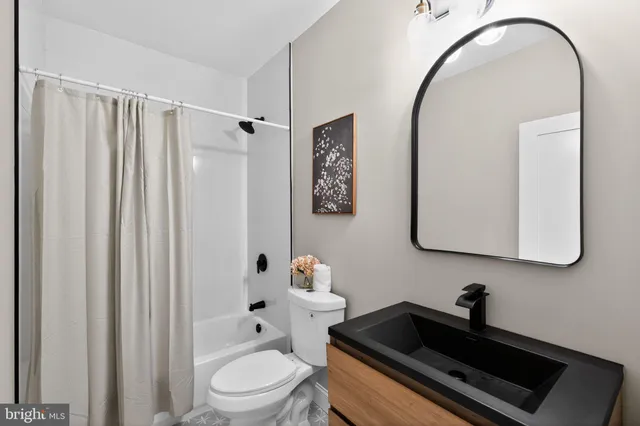 a bathroom with a sink a toilet and shower curtain