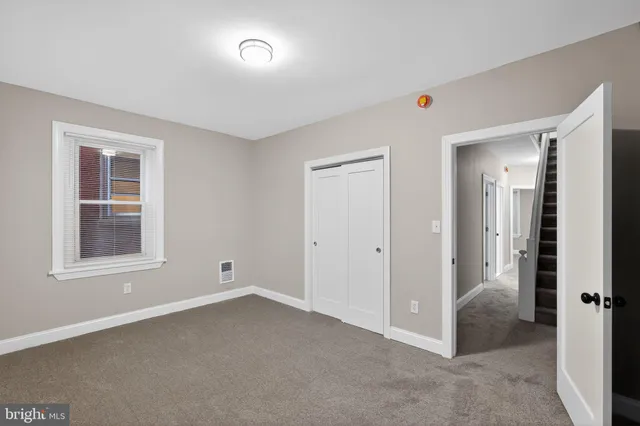 an empty room with windows and closet