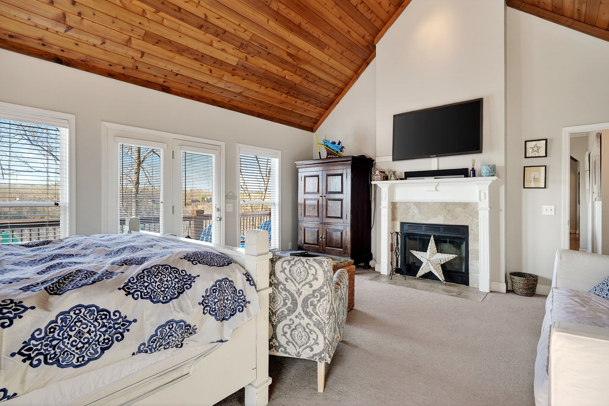 1175 Hutchins Bend Road Sparta, TN 38583 - Photo 29 of 76 a spacious bedroom with a bed a flat screen tv and a fireplace