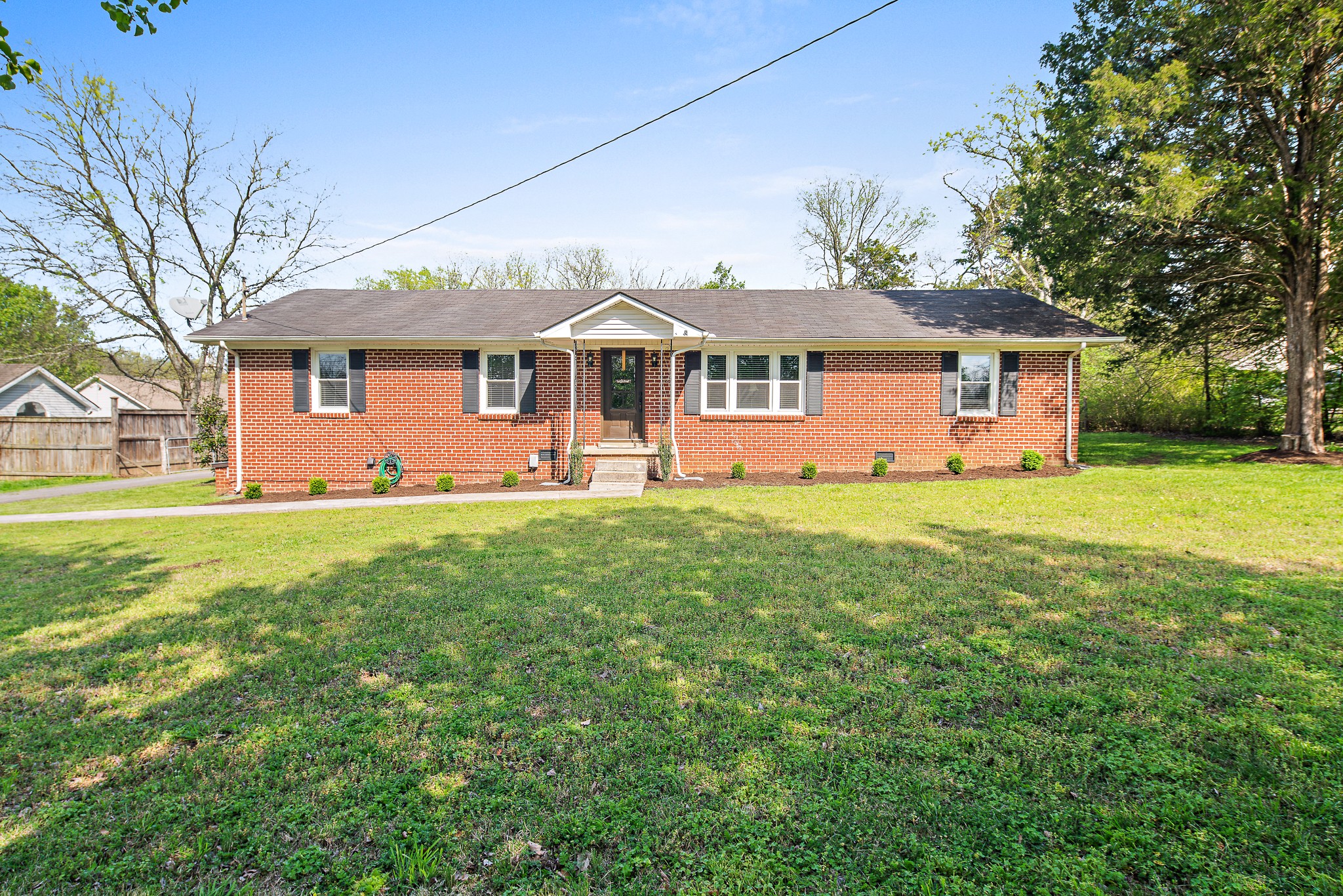 9161 Versailles Road Rockvale, TN 37153 - Photo 2 of 32 a front view of a house with a garden and trees