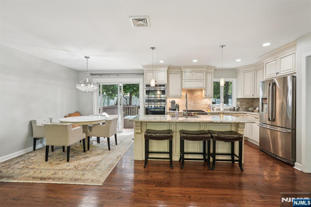 63 Crestmont Road West Orange, NJ 07052 - Photo 14 of 40 a dining hall with stainless steel appliances granite countertop a dining table and chairs with wooden floor