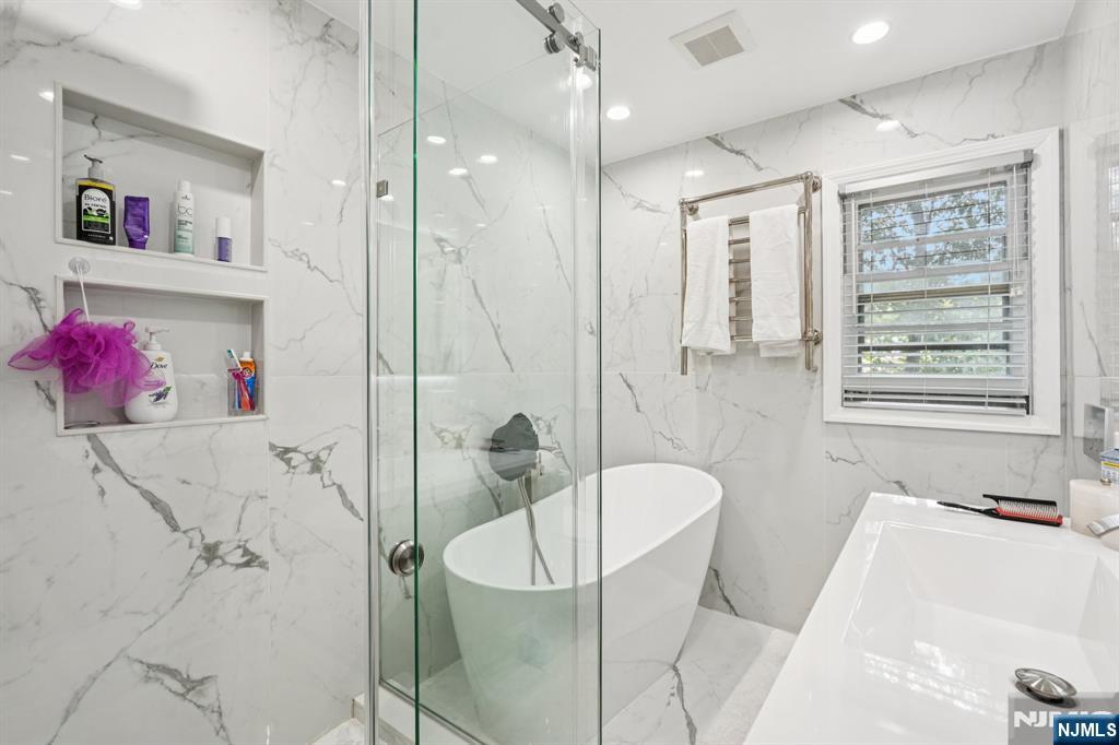 63 Crestmont Road West Orange, NJ 07052 - Photo 16 of 40 a bathroom with a tub a window and a shower