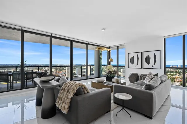 a living room with furniture and floor to ceiling windows
