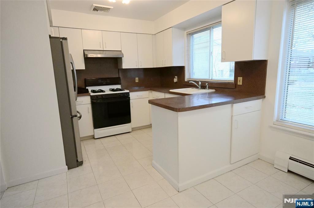 436 Brinkerhoff Avenue, Unit RIGHT Fort Lee, NJ 07024 - Photo 2 of 10 a kitchen with stainless steel appliances a stove and a refrigerator