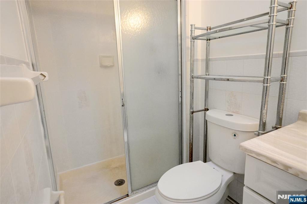 436 Brinkerhoff Avenue, Unit RIGHT Fort Lee, NJ 07024 - Photo 4 of 10 a white toilet sitting next to a shower