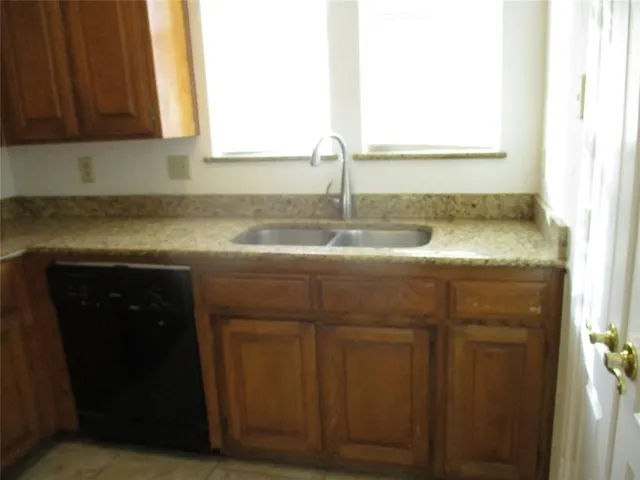 a kitchen with granite countertop cabinets sink and window