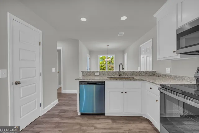 a kitchen with granite countertop a stove top oven microwave and cabinets