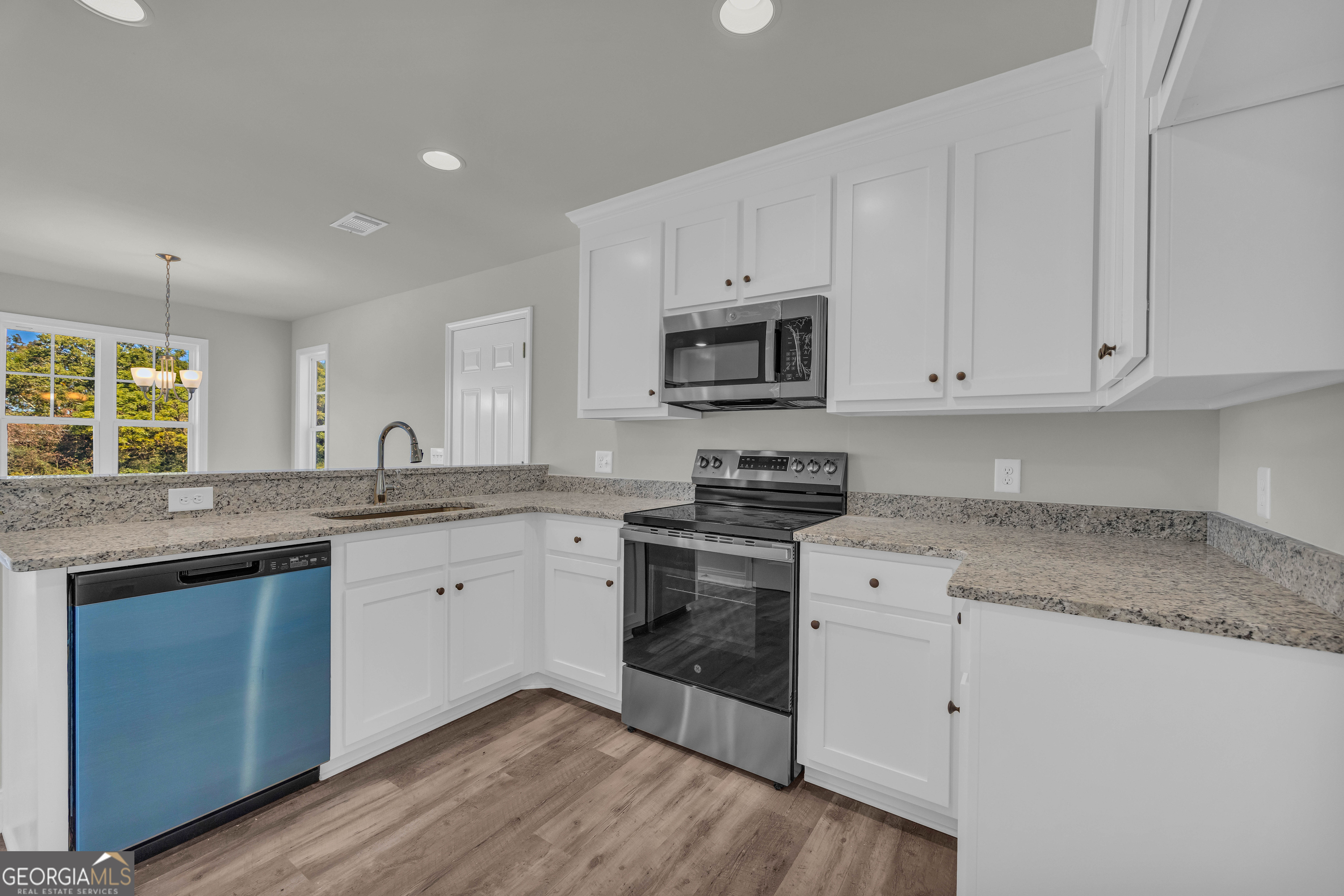 62 Sewell Road Lavonia, GA 30553 - Photo 18 of 63 a kitchen with granite countertop white cabinets and white appliances