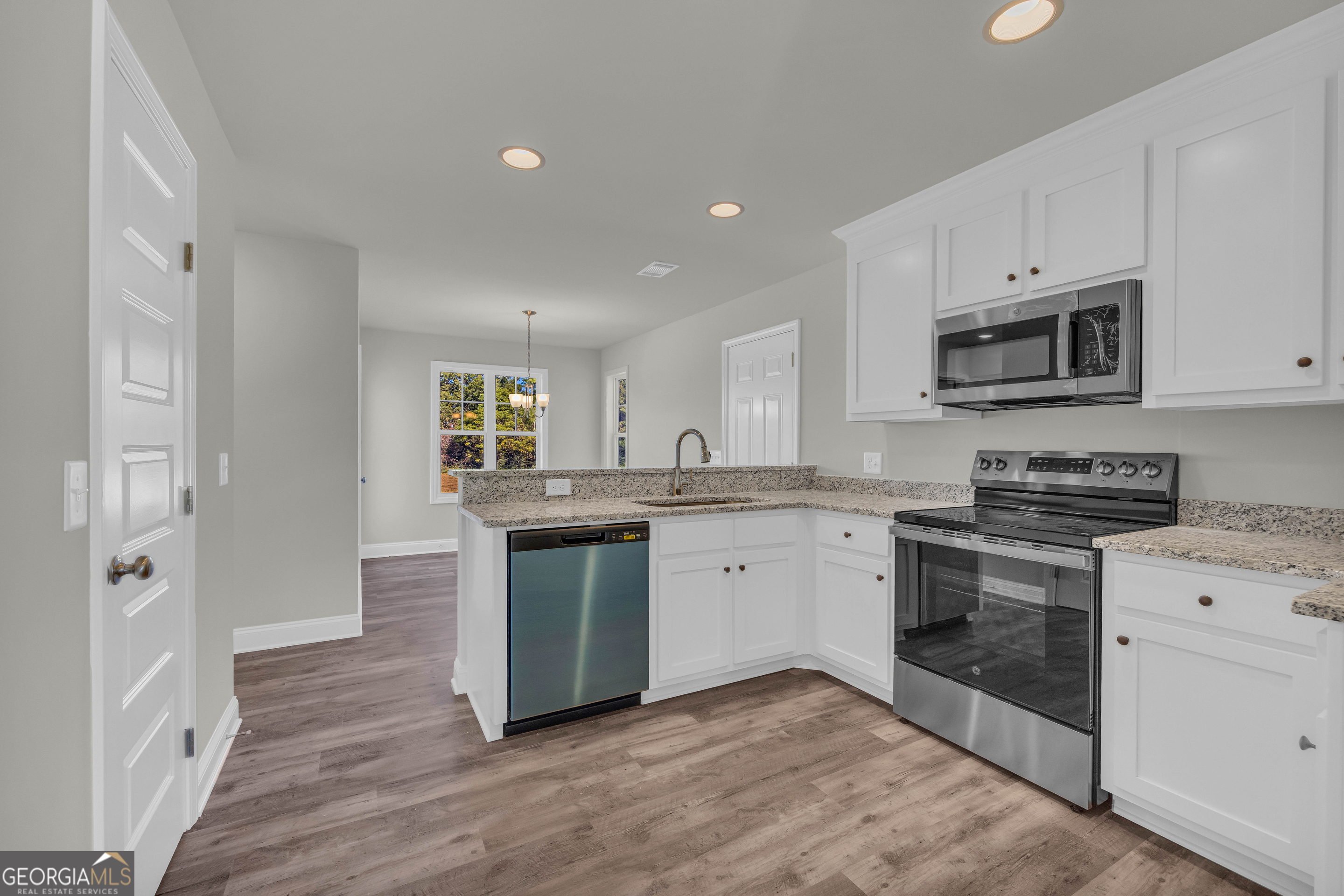 62 Sewell Road Lavonia, GA 30553 - Photo 19 of 63 a kitchen with granite countertop a stove top oven microwave and cabinets
