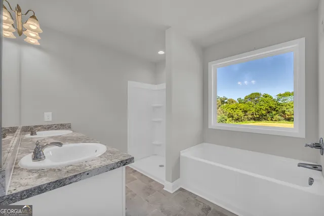 a bathroom with a granite countertop bathtub a sink and a mirror
