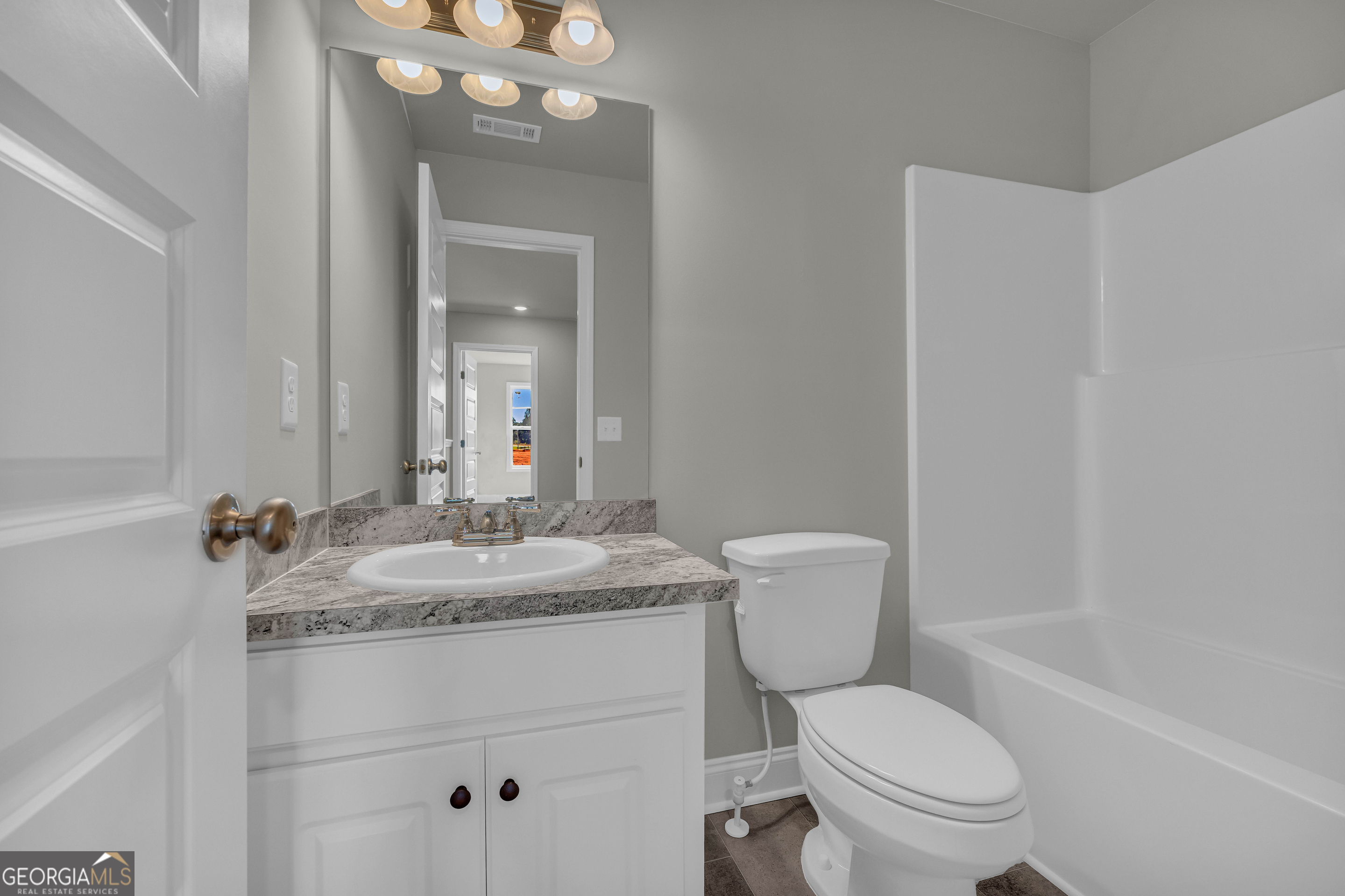 62 Sewell Road Lavonia, GA 30553 - Photo 40 of 63 a bathroom with a granite countertop toilet sink and mirror