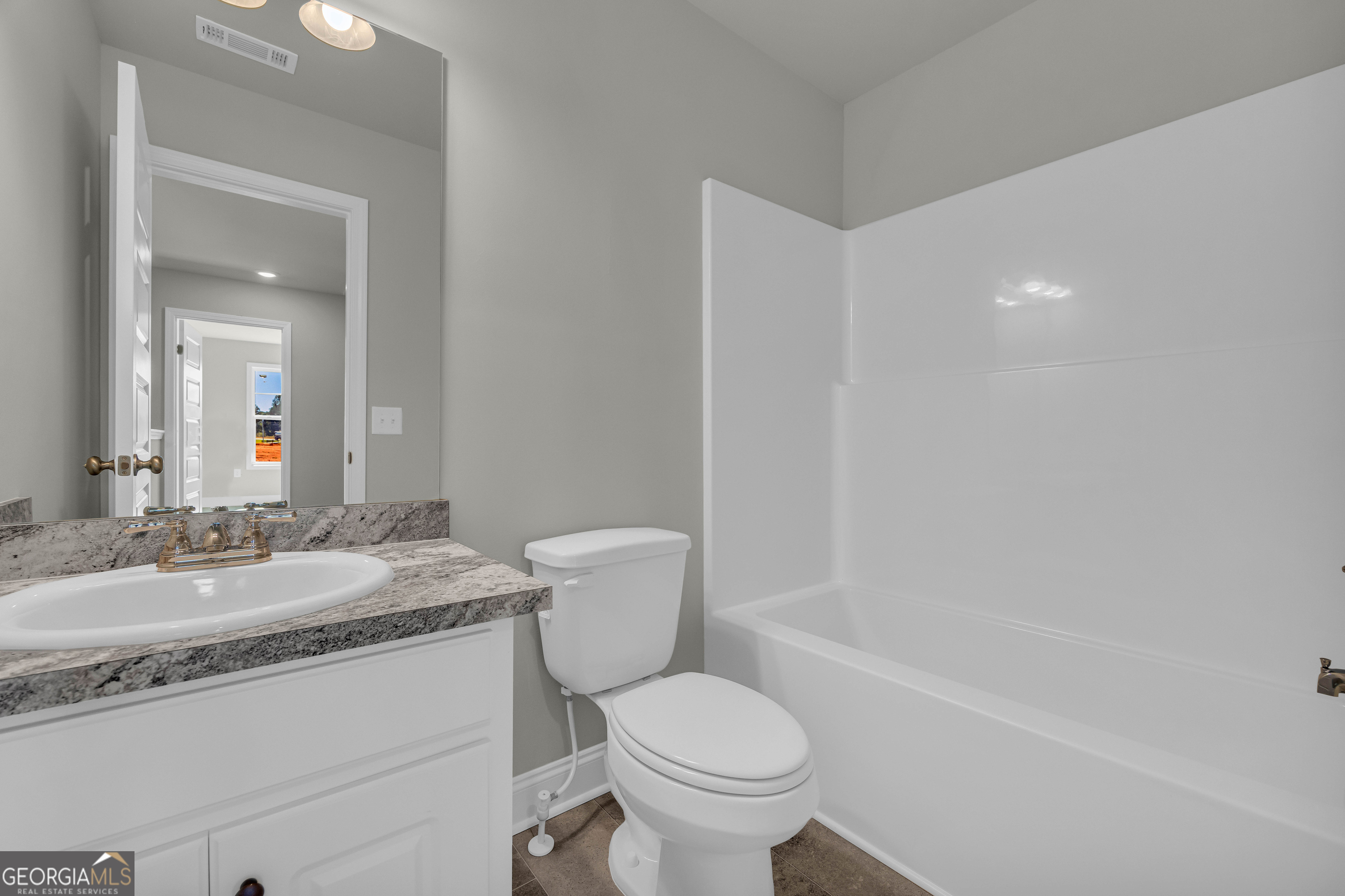 62 Sewell Road Lavonia, GA 30553 - Photo 41 of 63 a bathroom with a granite countertop toilet a sink and a mirror