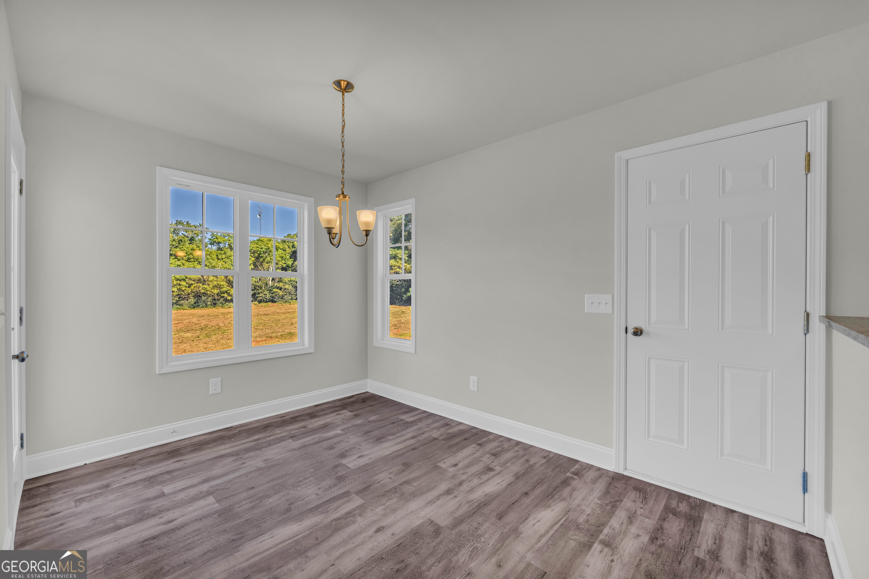 62 Sewell Road Lavonia, GA 30553 - Photo 8 of 63 a view of an empty room with wooden floor and a window