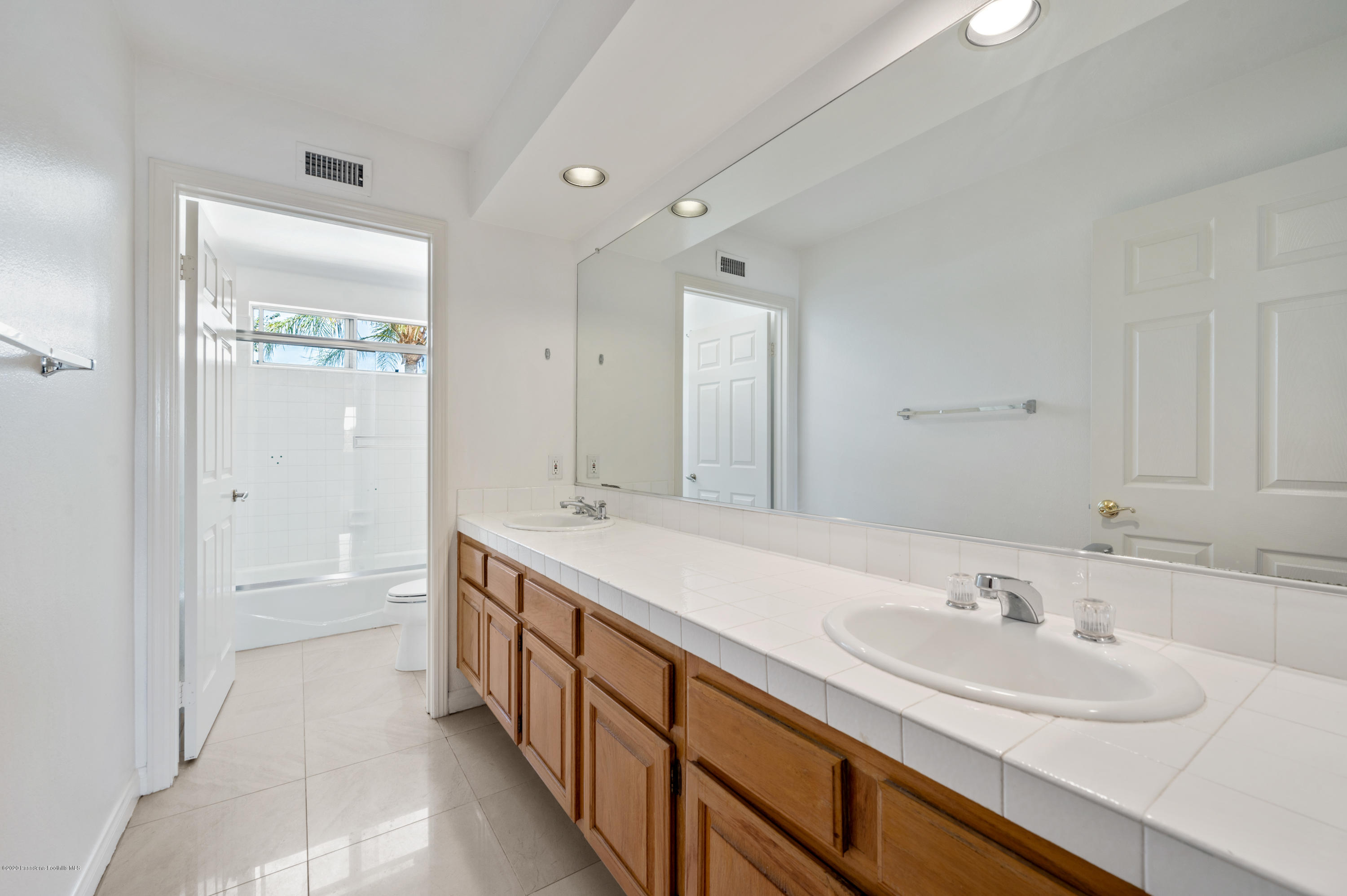 10652 Rathburn Avenue Porter Ranch, CA 91326 - Photo 23 of 61 a bathroom with a sink double vanity granite tub shower and a mirror