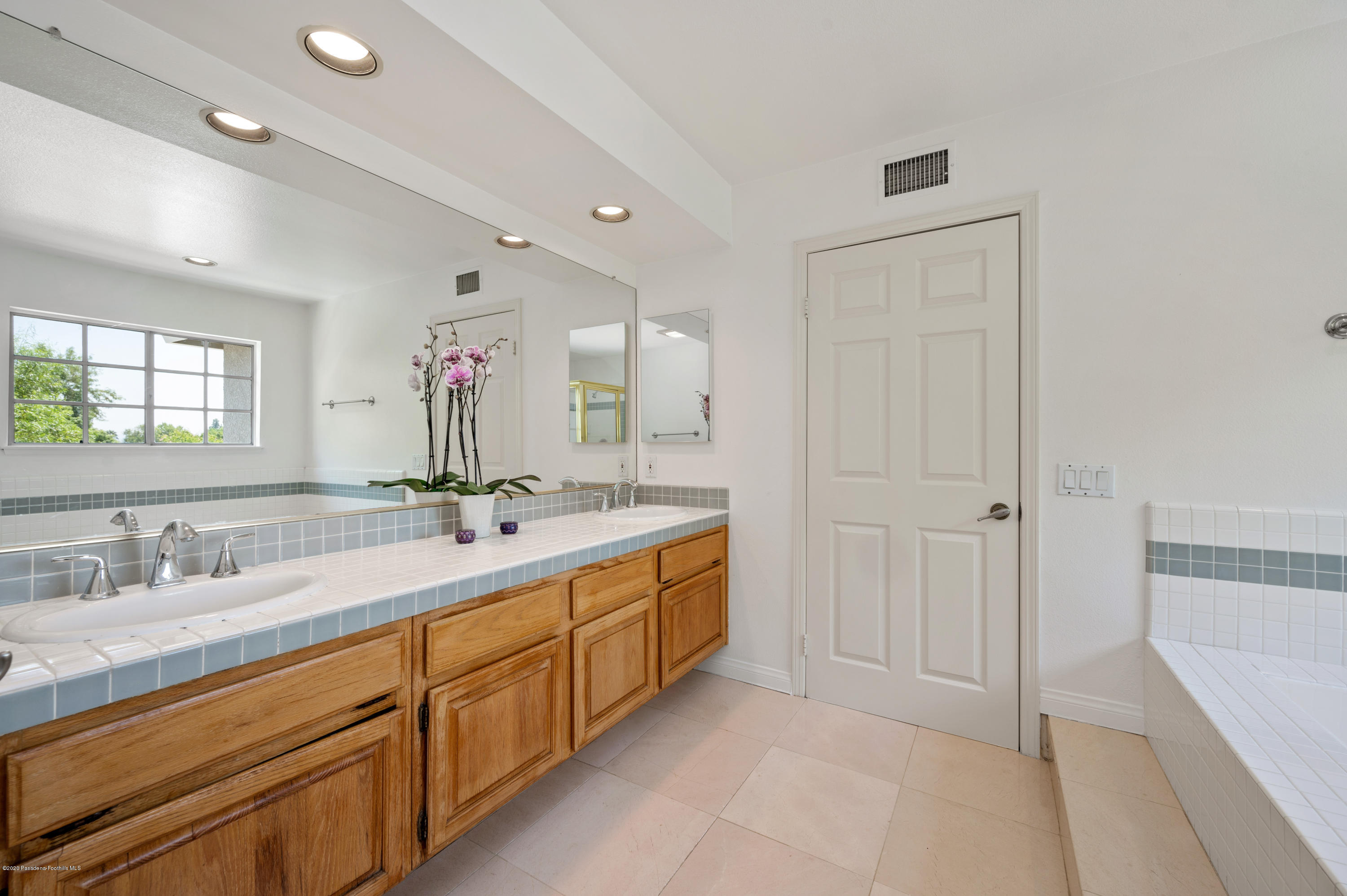 10652 Rathburn Avenue Porter Ranch, CA 91326 - Photo 30 of 61 a bathroom with a double vanity sink and a mirror