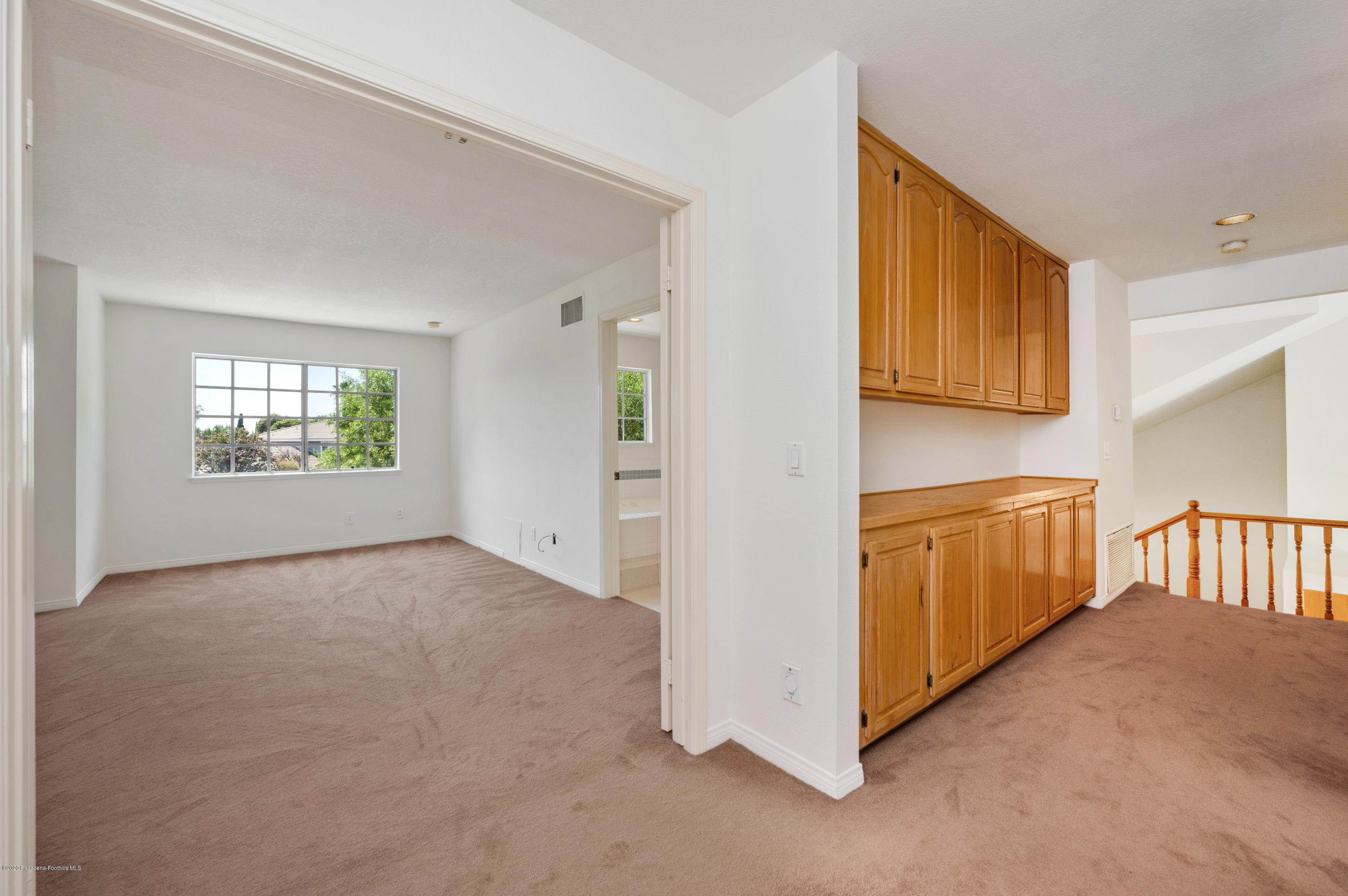 10652 Rathburn Avenue Porter Ranch, CA 91326 - Photo 35 of 61 a view of an empty room with windows & cabinet
