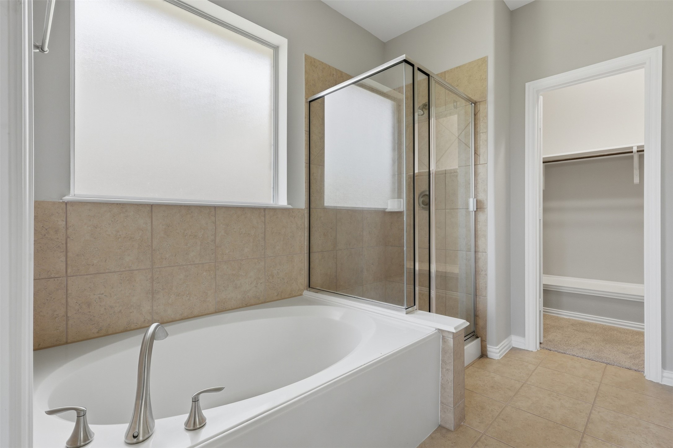 25926 Morgan Springs Spring, TX 77373 - Photo 23 of 49 Unwind in the luxurious soaking tub after a long day, bubble you away or enjoy the separate glass-enclosed shower. Thoughtfully designed with natural light and generous space, this bathroom offers everyday comfort and convenience. Frost window to allow the natural lighting in but no one can see in!