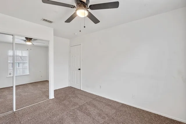 an empty room with fan and windows
