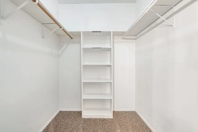 a view of walk in closet with empty racks