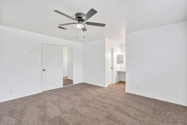 a view of a big room with chandelier fan and windows