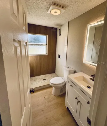a bathroom with a sink a toilet a mirror and shower